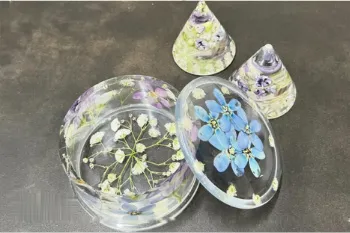 青や白の小花を封入した、レジンの円形トレーと円すい形の小物