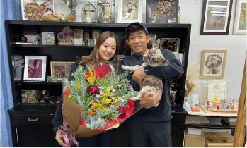 花束を抱えたお客様ご夫婦と猫